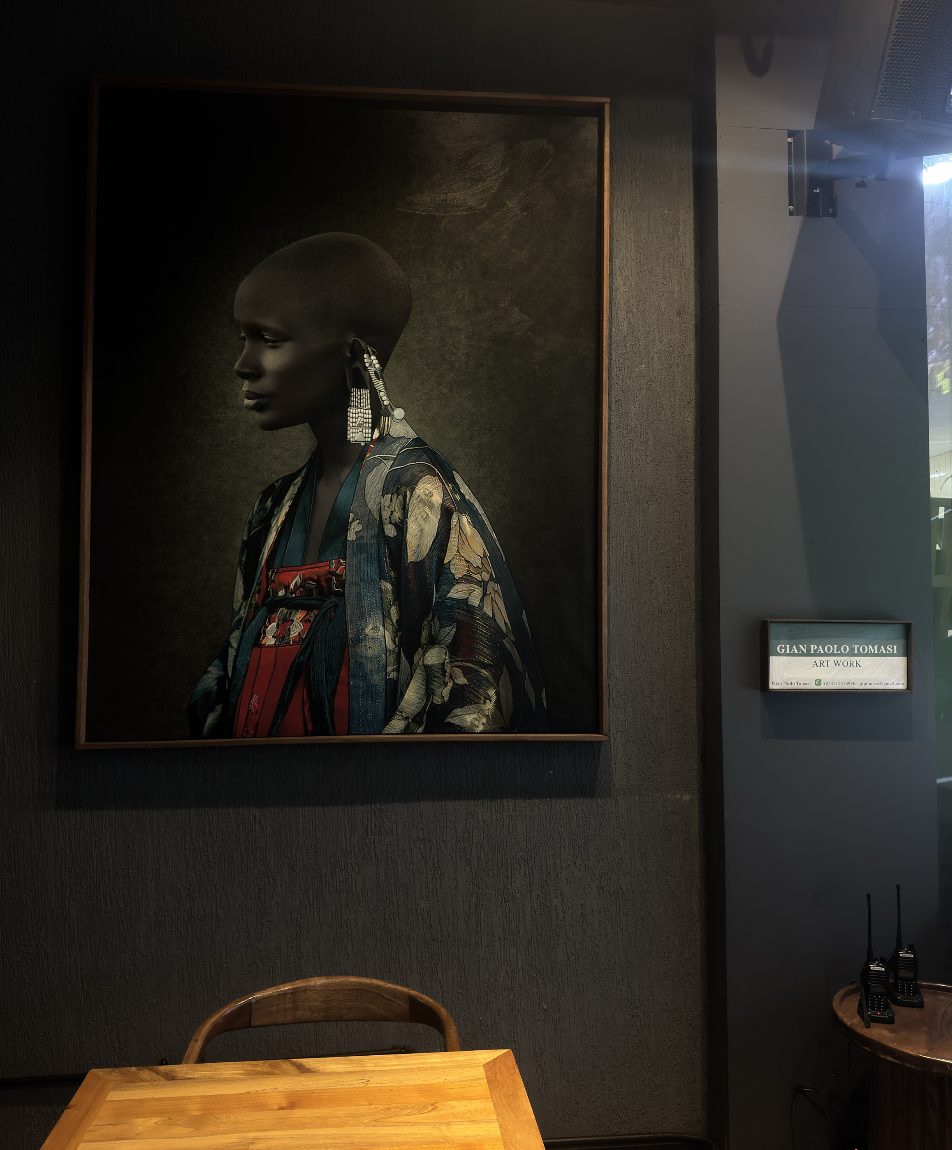 Profile of a woman in a floral kimono with long beaded earrings, on a dark wall
