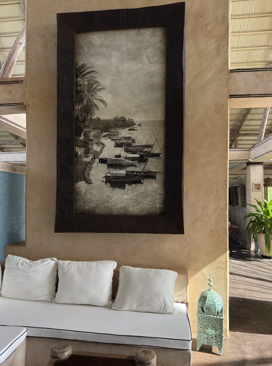 Tall print of moored boats above a sofa