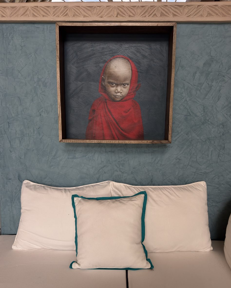 Portrait of a child in red above white cushions